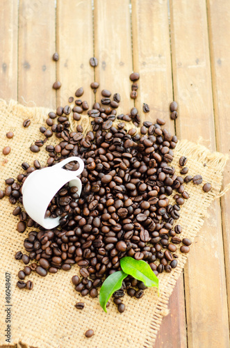 coffee beans with white cup and green leaves
