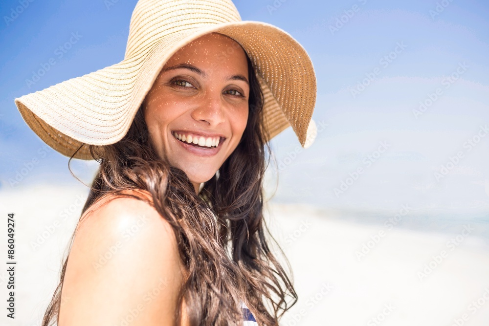 Pretty brunette looking at camera at the beach