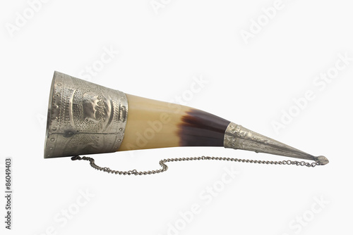 Caucasian wine-drinking horn. Isolated caucasian wine-drinking horn with decorative metal elements lying on a white background.