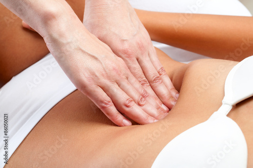 Therapist Hands pressing on female abdomen.