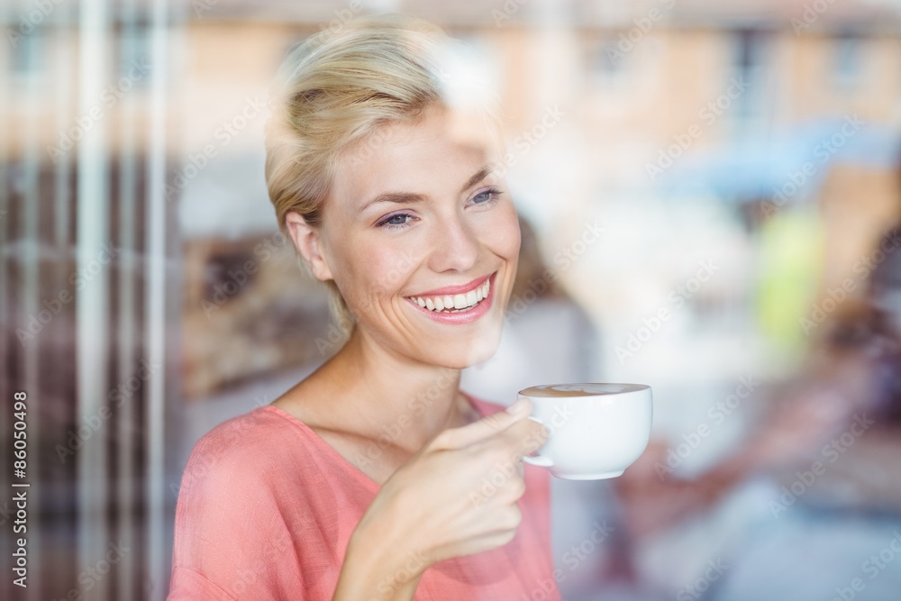 Happy blonde woman drinking a cup of coffee Happy blonde woman drinking a cup of coffee