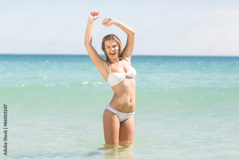 Happy pretty blonde cheering into the sea Happy pretty blonde cheering into the sea