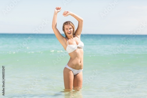 Happy pretty blonde cheering into the sea 