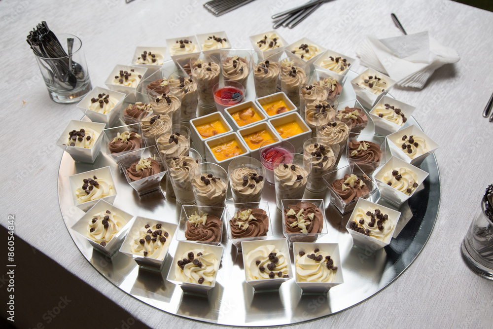 Naklejka premium Assortimento di dolci in crema su vassoio rotondo specchiato