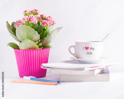 Workplace with flower books and a coffee cup with text 'I love my job"