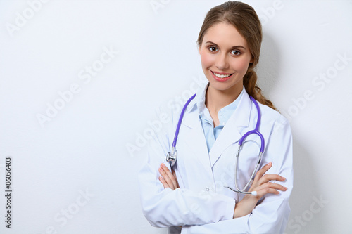 Young female doctor, standing near wall