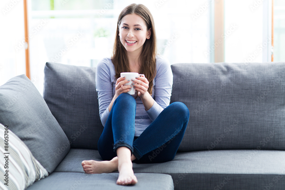 Fototapeta premium Woman drinking coffee on sofa