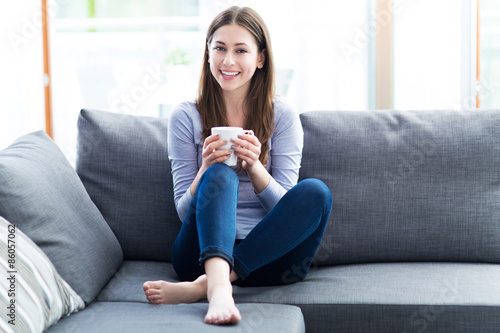 Woman drinking coffee on sofa