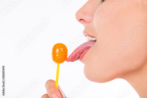 Schilderij op canvas closeup photo of girl licking a lollipop