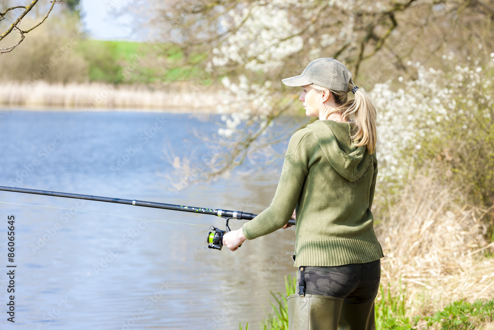 woman fishing at pond in spring