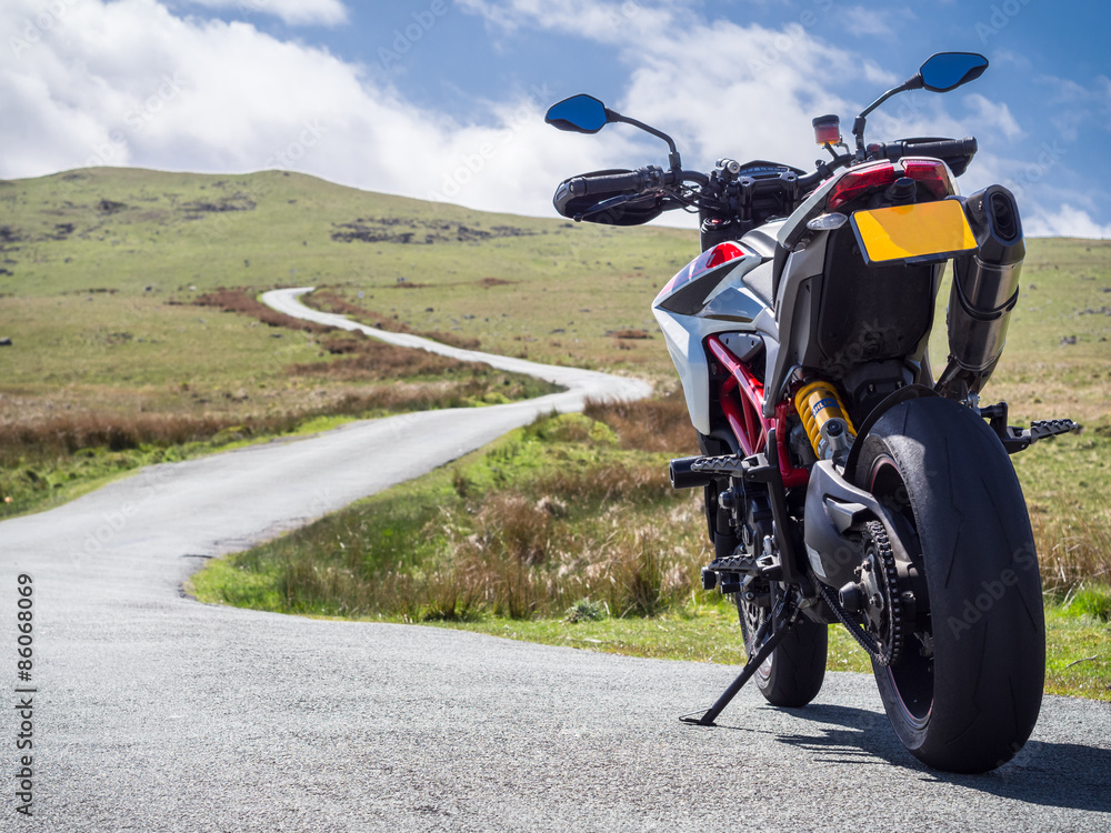 Fototapeta premium A supermotard type motorcycle facing towards the winding road ahead