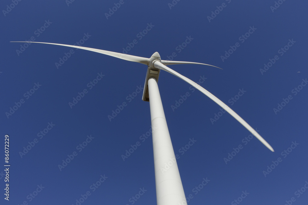Low-angle shot of windmill with daytime moon in the sky Low-angle shot of windmill with daytime moon in the sky