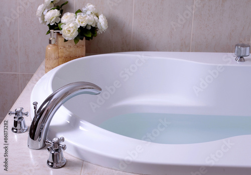 white bath tub with faucet and mozaic tiles photo