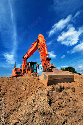 Erdaushub mit Bagger vor blauem Himmel photo