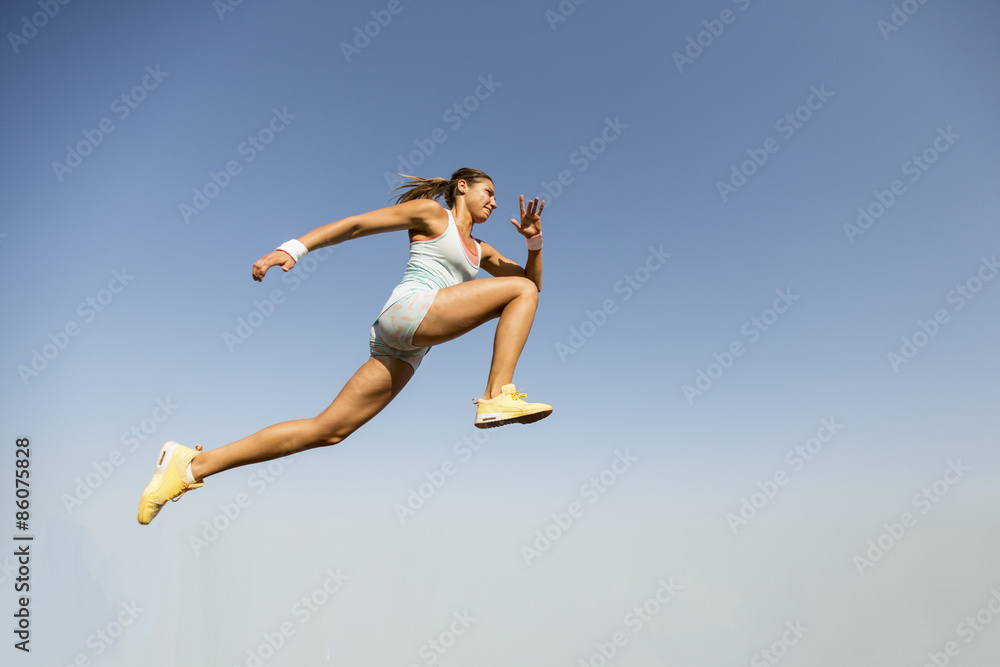 Young woman taking long jump