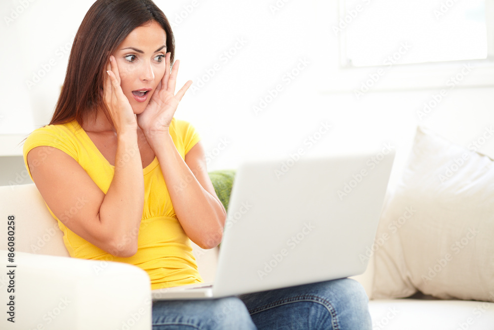 Young student looking shocked while using a laptop Young student looking shocked while using a laptop