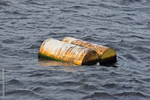 Two yellow barrels drift on water