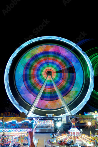 Colorful ferris wheel in motion at night