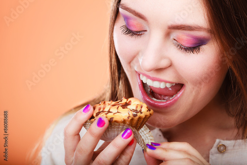 Smiling woman holds cake in hand