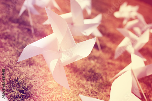 paper windmill in green grass field, vintage sretro style photo