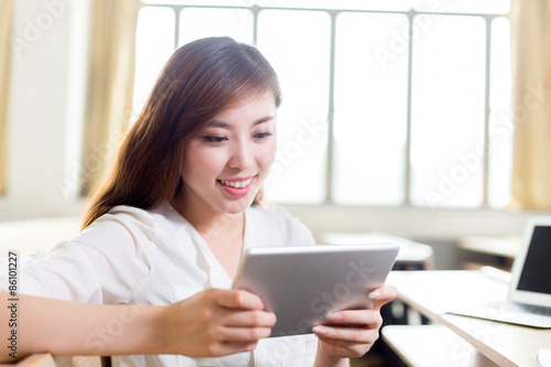 Asian beautiful female student study in classroom with tablet