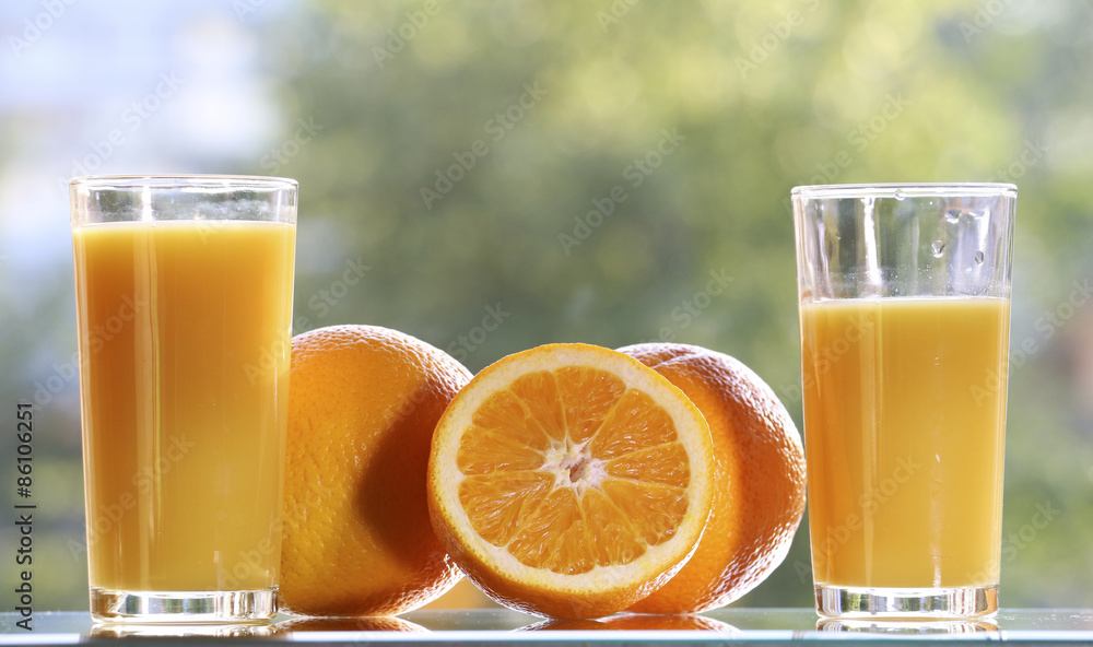 Oranges and orange juice on a green background. Oranges and orange juice on a green background.