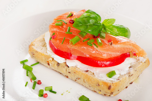 Sandwich with cereals bread and salmon on plate.