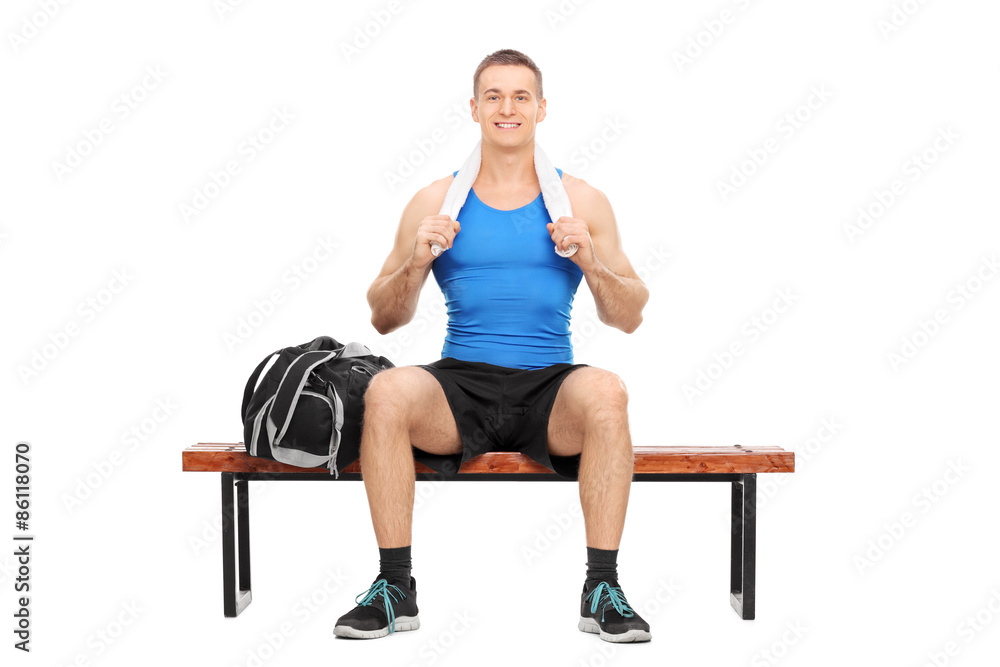 Young athlete posing seated on a wooden bench Young athlete posing seated on a wooden bench