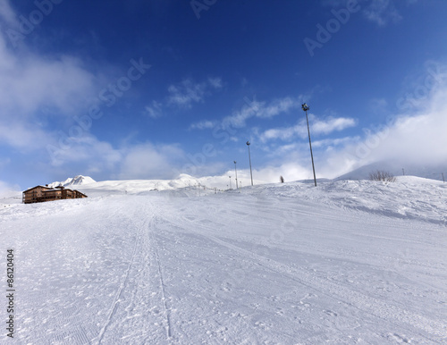 Ski slope and hotel in winter mountains