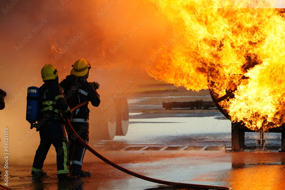Obraz premium firefighters fighting large factory fire