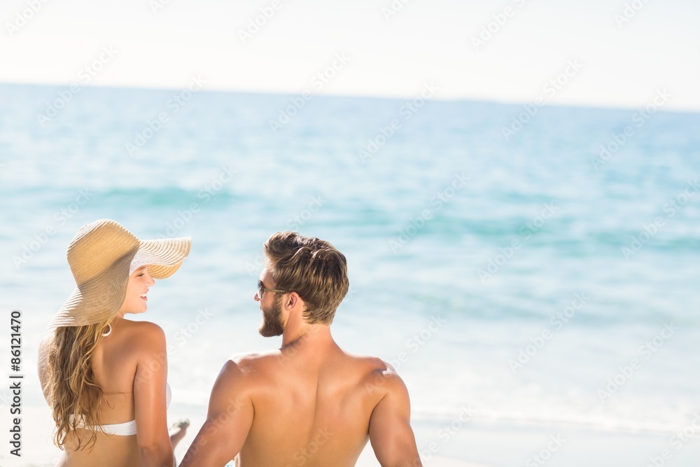 Happy couple relaxing together in the sand