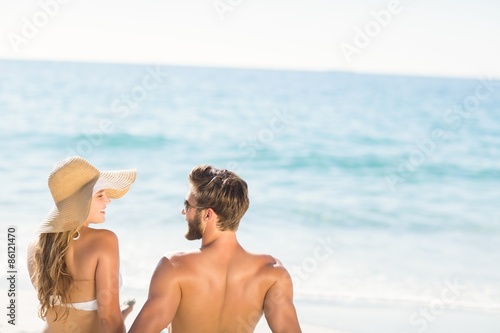 Happy couple relaxing together in the sand
