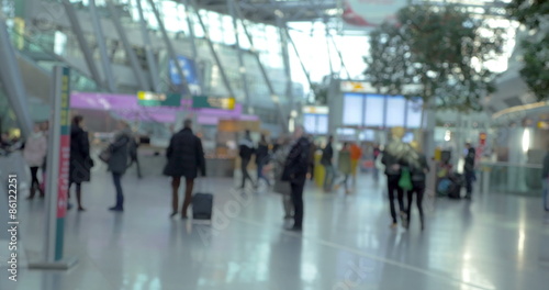 Passengers walking around big and light airport hall