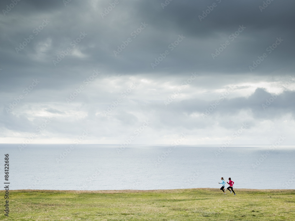 Two women jogging along the coast. Two women jogging along the coast.