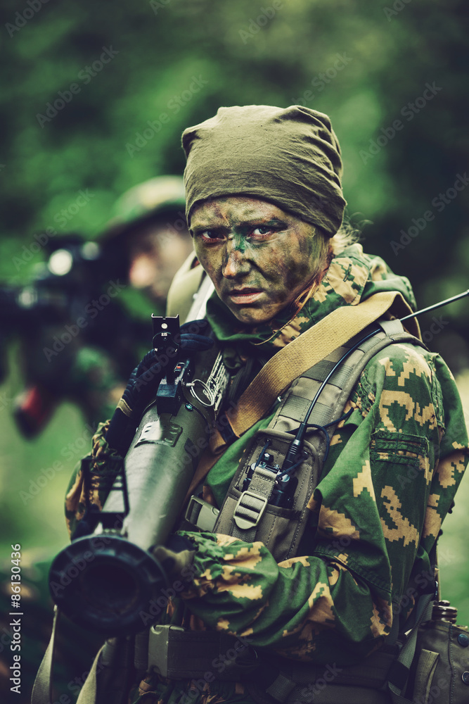 woman soldier with a grenade launcher in his hands in forest are