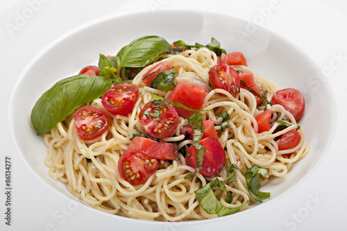 Plate of pasta with fresh tomatoes and basil .