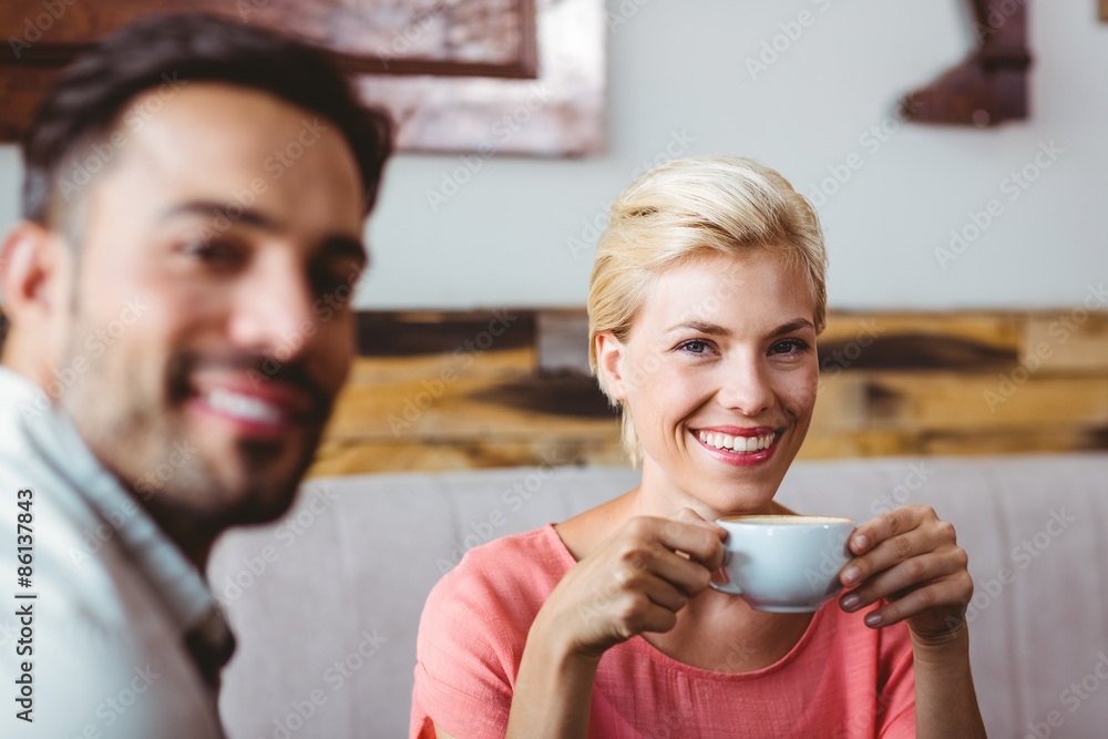 Couple with coffee cup sitting on sofa Couple with coffee cup sitting on sofa