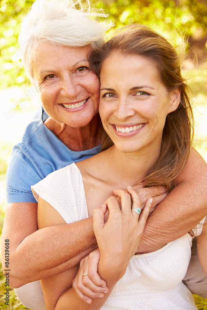Senior woman sitting outdoors with her adult daughter Senior woman sitting outdoors with her adult daughter