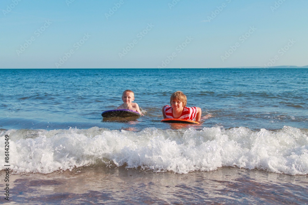 Two boys body boarding together