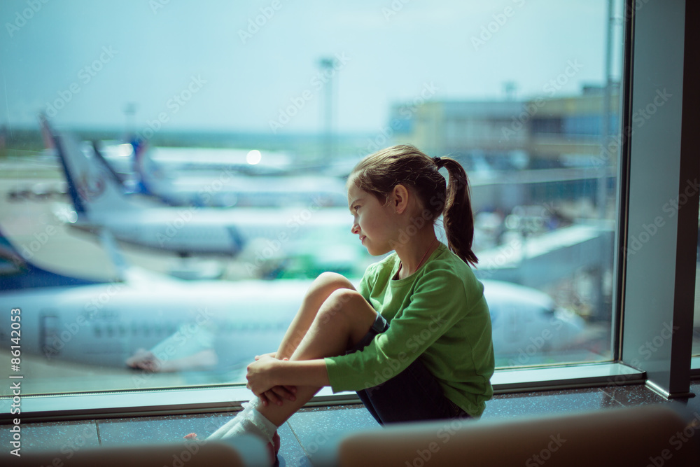 Child At The Airport Near The Window Looking At Airplanes And Waiting Child At The Airport Near The Window Looking At Airplanes And Waiting