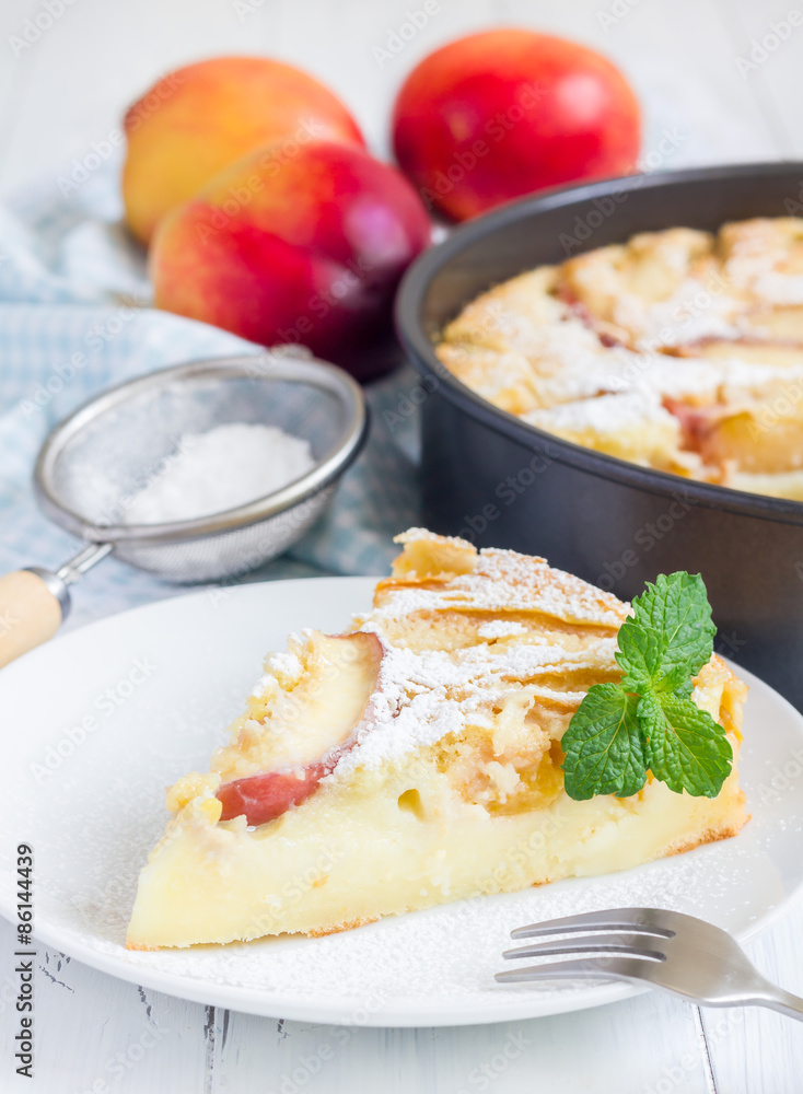 Slice of peach clafoutis on a white plate