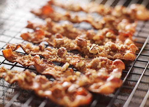 candied bacon with pecans and brown sugar cooling on baking rack