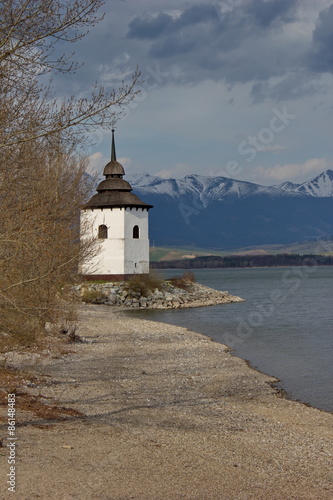 old church of Virgin Mary on coast of Liptovska Mara and Tatras, Liptov, Slov...