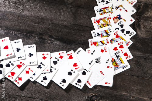 Carte da gioco disposte a cornice su tavolo di legno photo