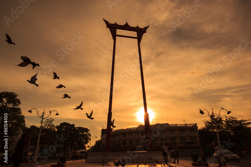 Photography Silhouette of flying birds and giant swing at sunset time in Bangkok, Thailand