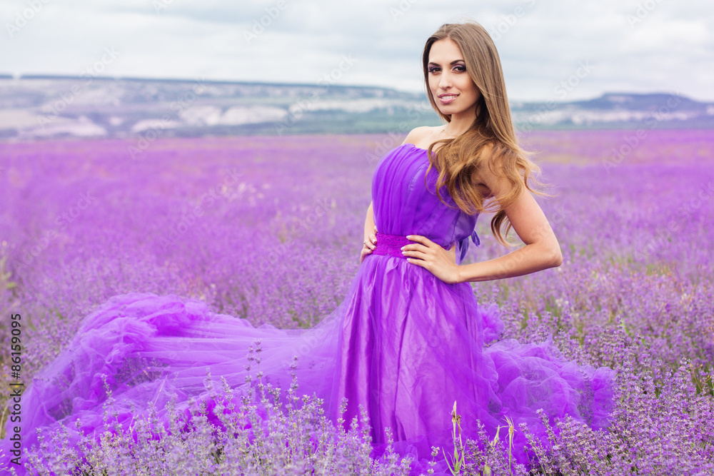 Beautiful smiling woman is wearing fashion dress at lavender Beautiful smiling woman is wearing fashion dress at lavender