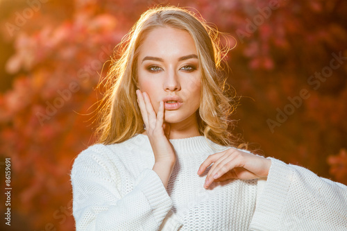 young woman on a background of red and yellow autumn leaves with