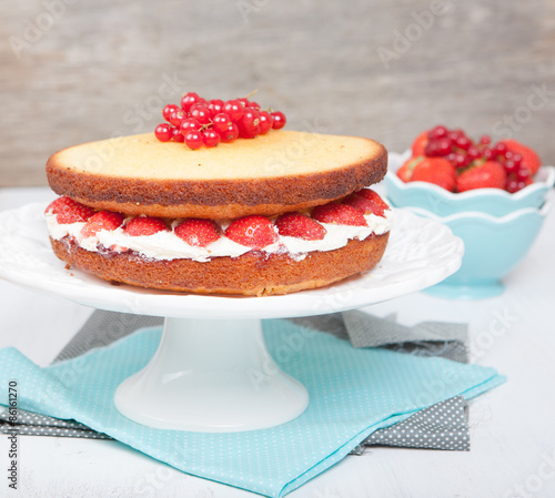 Victoria sponge cake with buttercream frosting, jam and strawberries