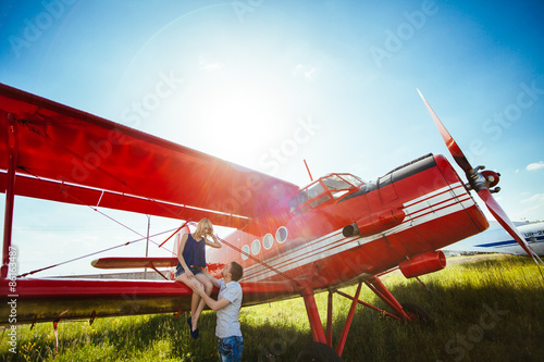 Stylish couple standing near a plane at the airport. honeymoon