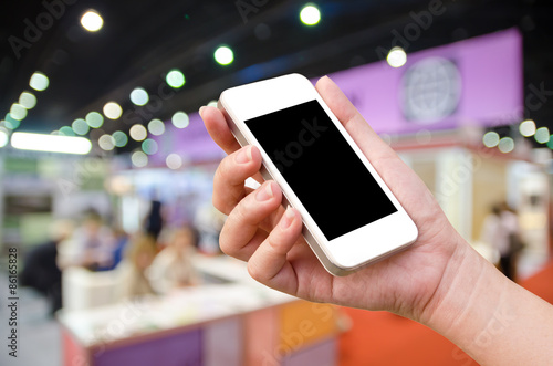 woman hand holding the phone tablet on blur event background photo